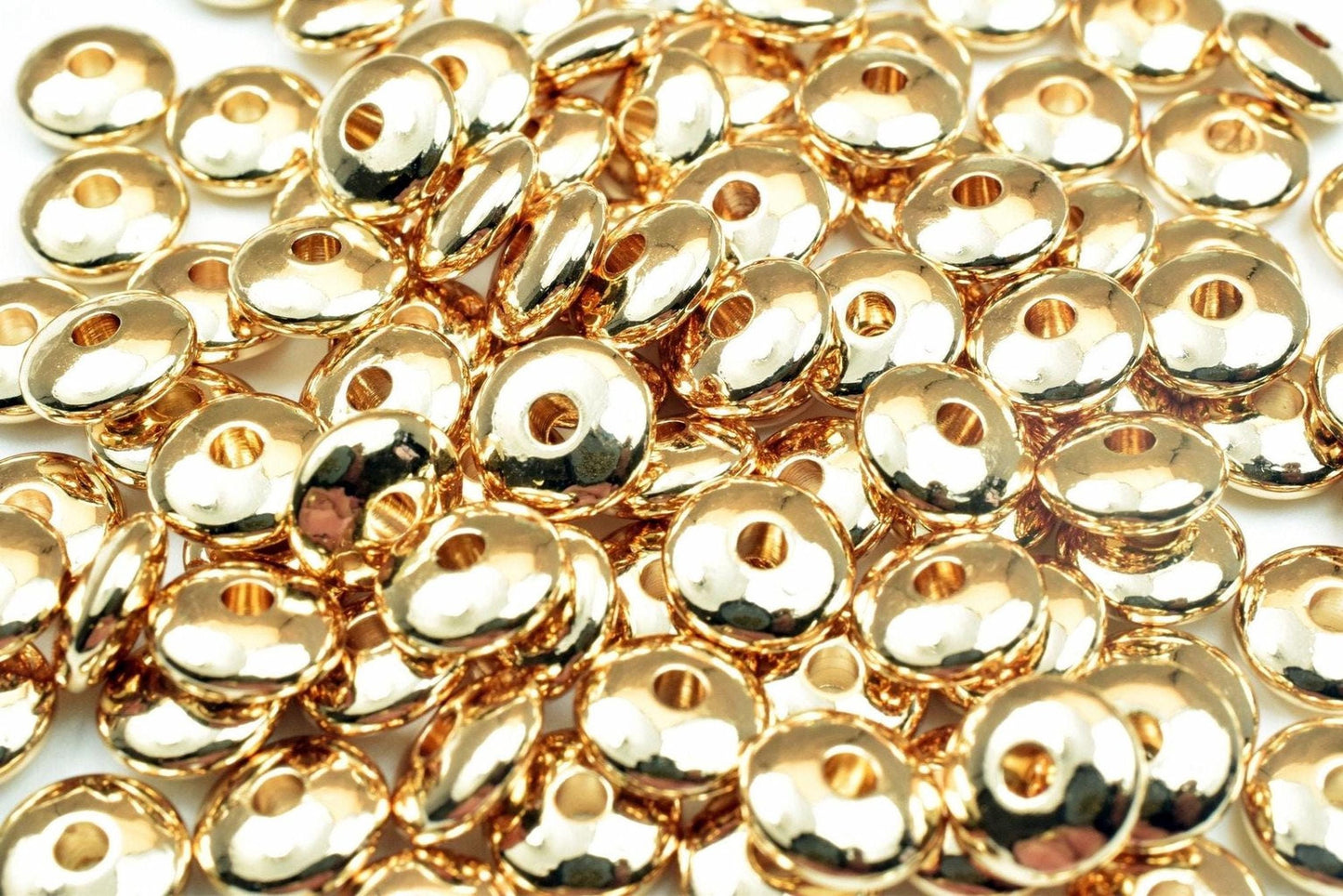 a close-up view of numerous shiny, golden-colored beads or coins scattered together.
