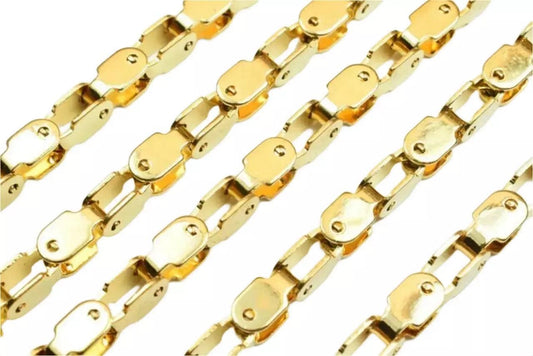 a close-up view of several gold-colored metal chains arranged in a repeating pattern.