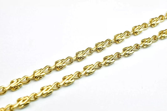 A close-up view of a gold chain with interlocking links, showcasing the intricate design and craftsmanship of the jewelry piece.