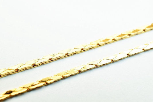 A close-up image of a gold chain necklace against a white background.