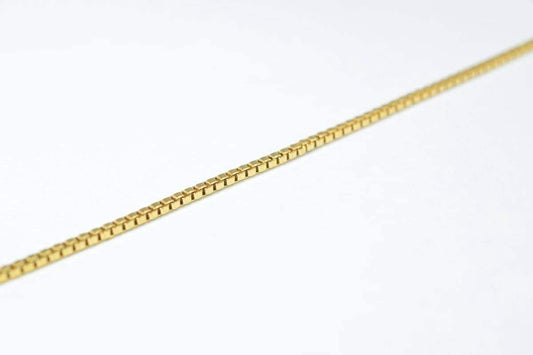 A gold chain necklace is shown against a white background.