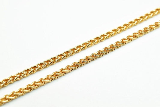 A close-up image of a gold chain necklace against a white background.