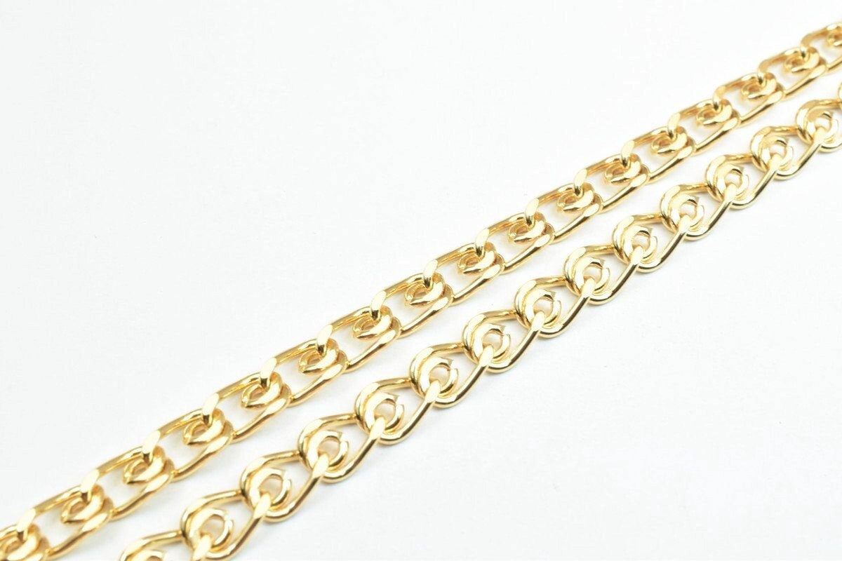 two gold-colored metal chains with interlocking links, arranged diagonally across a white background.
