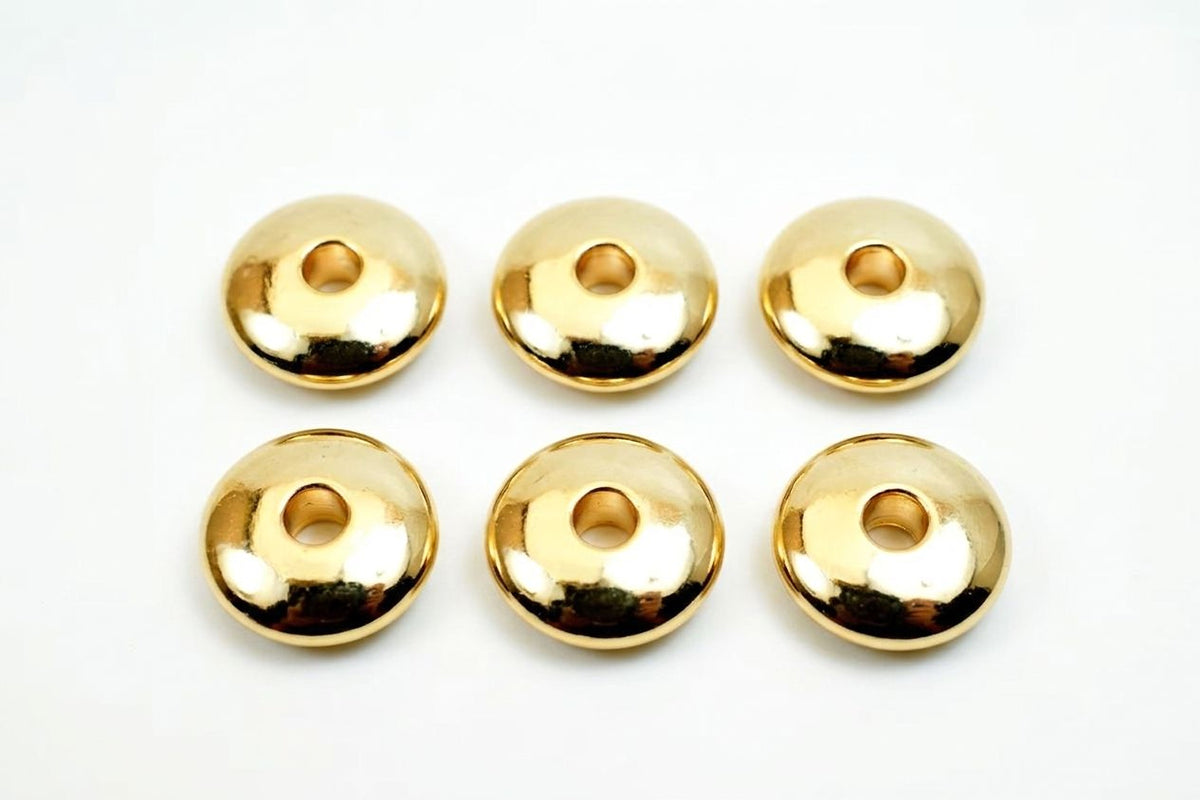 Six shiny gold-colored donut-shaped objects are arranged in a grid on a white background.