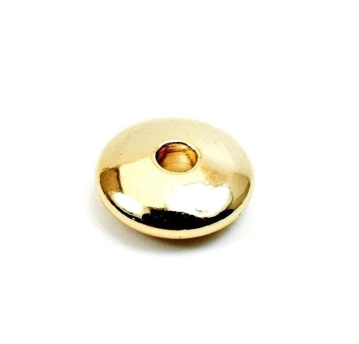A shiny, golden-colored object with a small hole in the center, sitting on a white background.