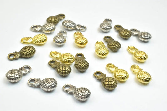 "Assorted gold and silver pineapple-shaped jewelry charms"