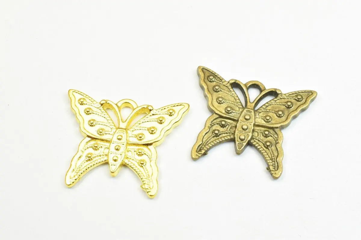 "Gold and bronze butterfly pendants with intricate design"