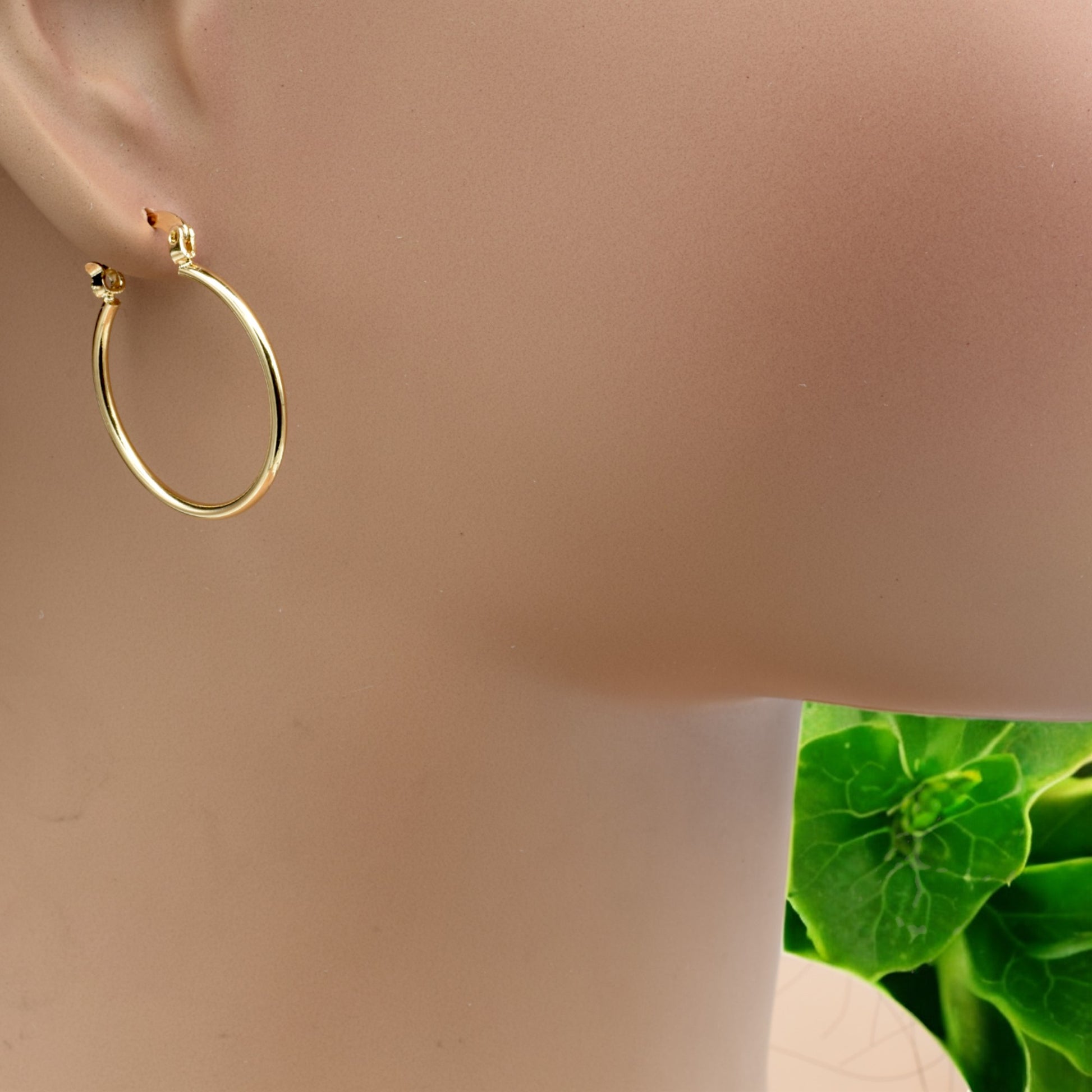 Display of gold hoop earrings in various sizes arranged on a stand, showcasing their sleek and polished finish.