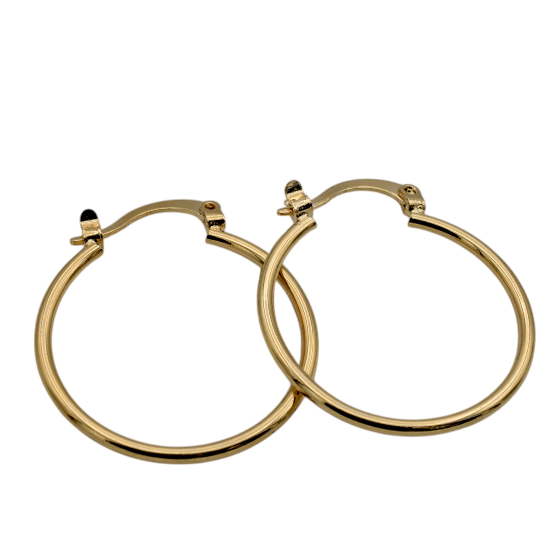 Display of gold hoop earrings in various sizes arranged on a stand, showcasing their sleek and polished finish.