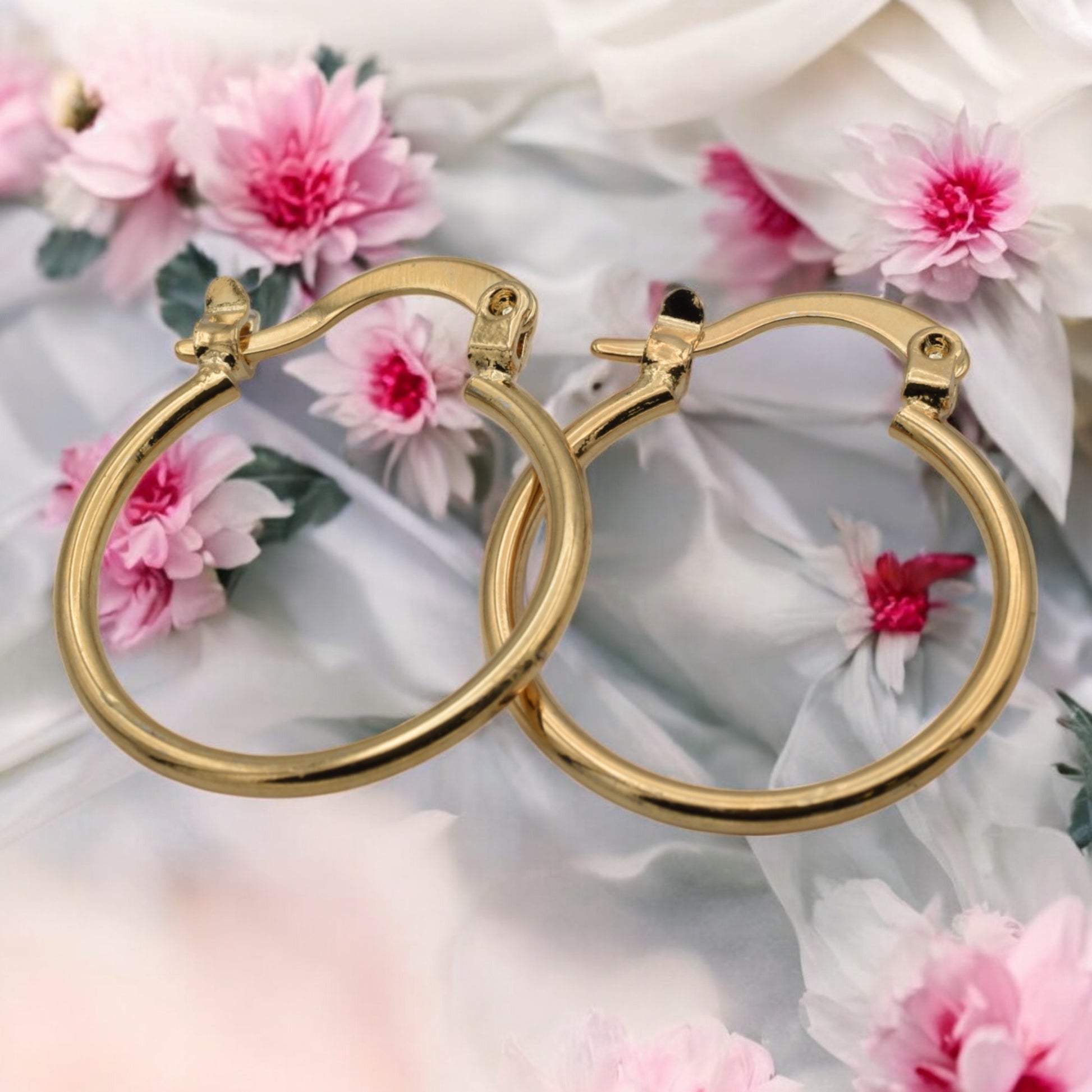 Display of gold hoop earrings in various sizes arranged on a stand, showcasing their sleek and polished finish.