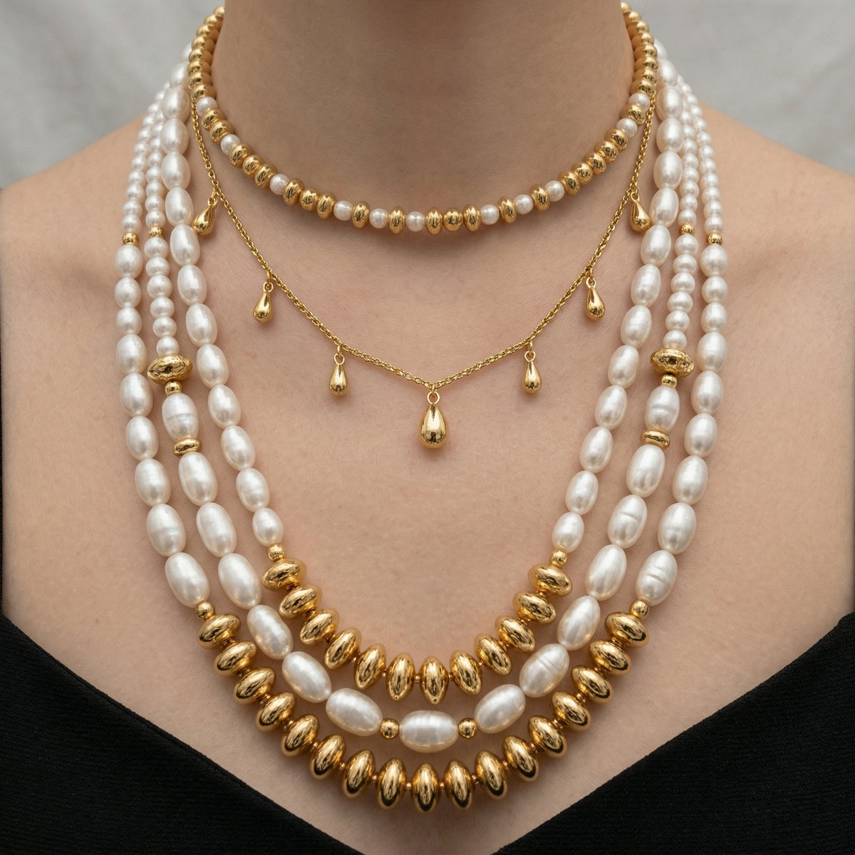A close-up of a woman's neck adorned with a multi-strand pearl necklace, featuring a combination of white pearls and gold beads.