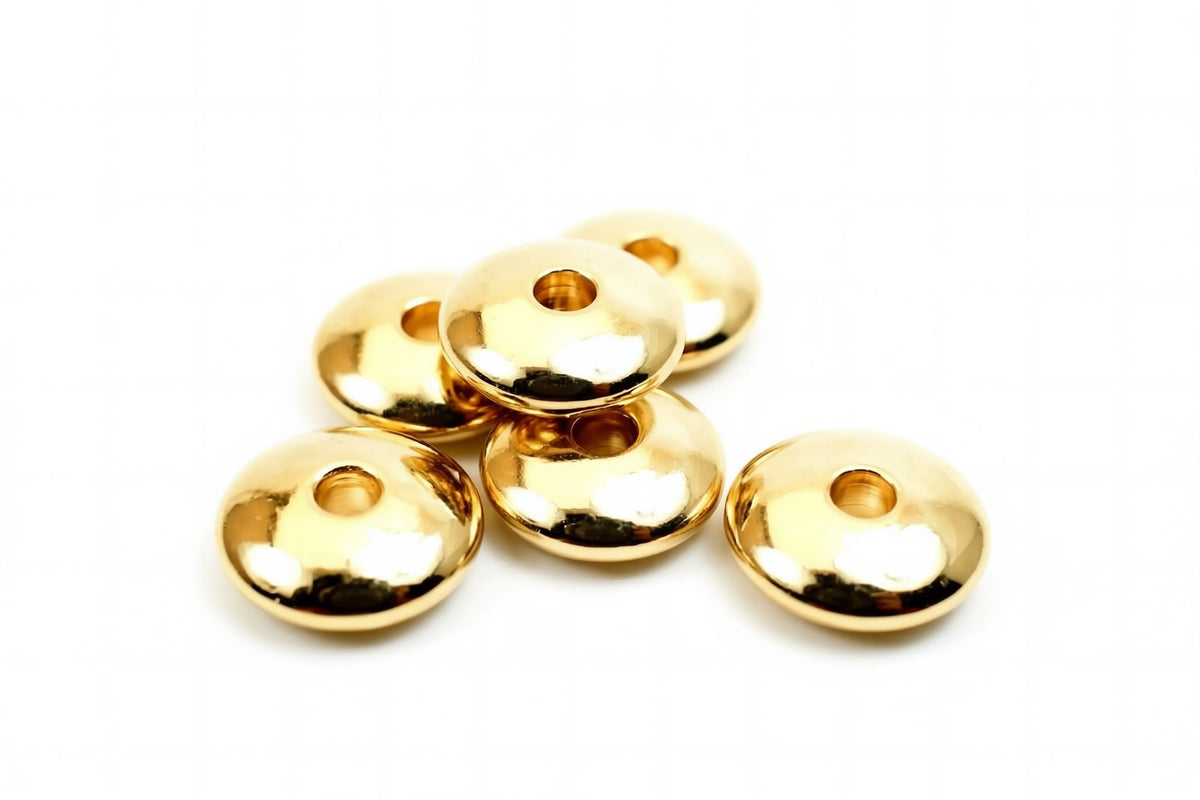 A group of shiny, golden-colored beads or buttons arranged on a white background.