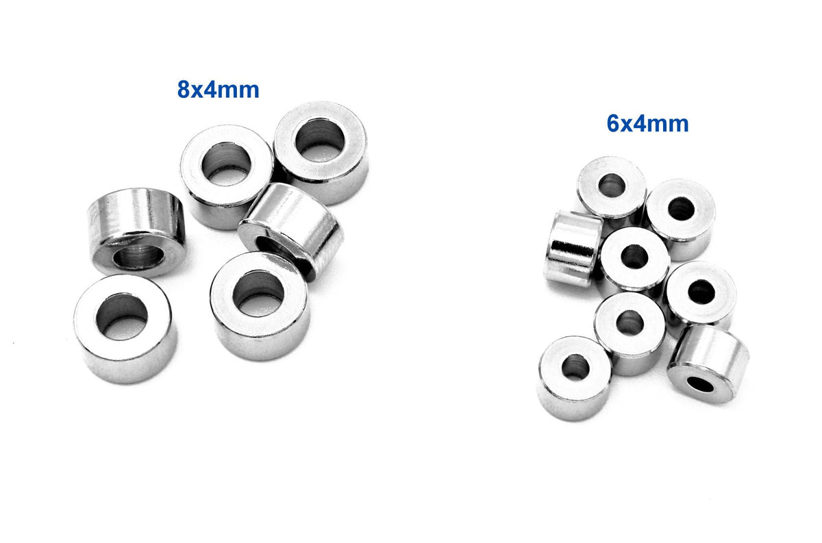 May include: Two sets of silver metal spacers. The set on the left is labeled "8x4mm" and contains six spacers. The set on the right is labeled "6x4mm" and contains nine spacers.
Surtido de hallazgos de joyería con cuentas rondel de acero inoxidable 6x4mm y 8x4mm