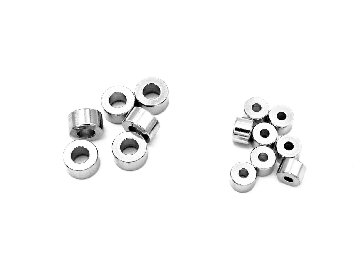 May include: A group of silver metal spacers, some are stacked on top of each other, and some are scattered on a white surface.
Cuentas separadoras resistentes de acero inoxidable para diseño y creación de joyas