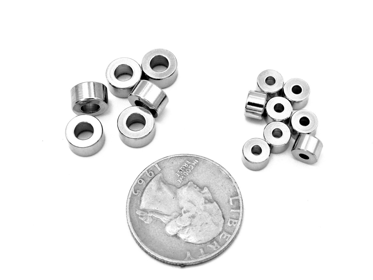 May include: A close-up of a group of silver metal spacers. The spacers are small and round, with a hole in the center. There are two groups of spacers, one with six spacers and the other with eight spacers. A US quarter is included for scale.
Cuentas separadoras resistentes de acero inoxidable para diseño y creación de joyas