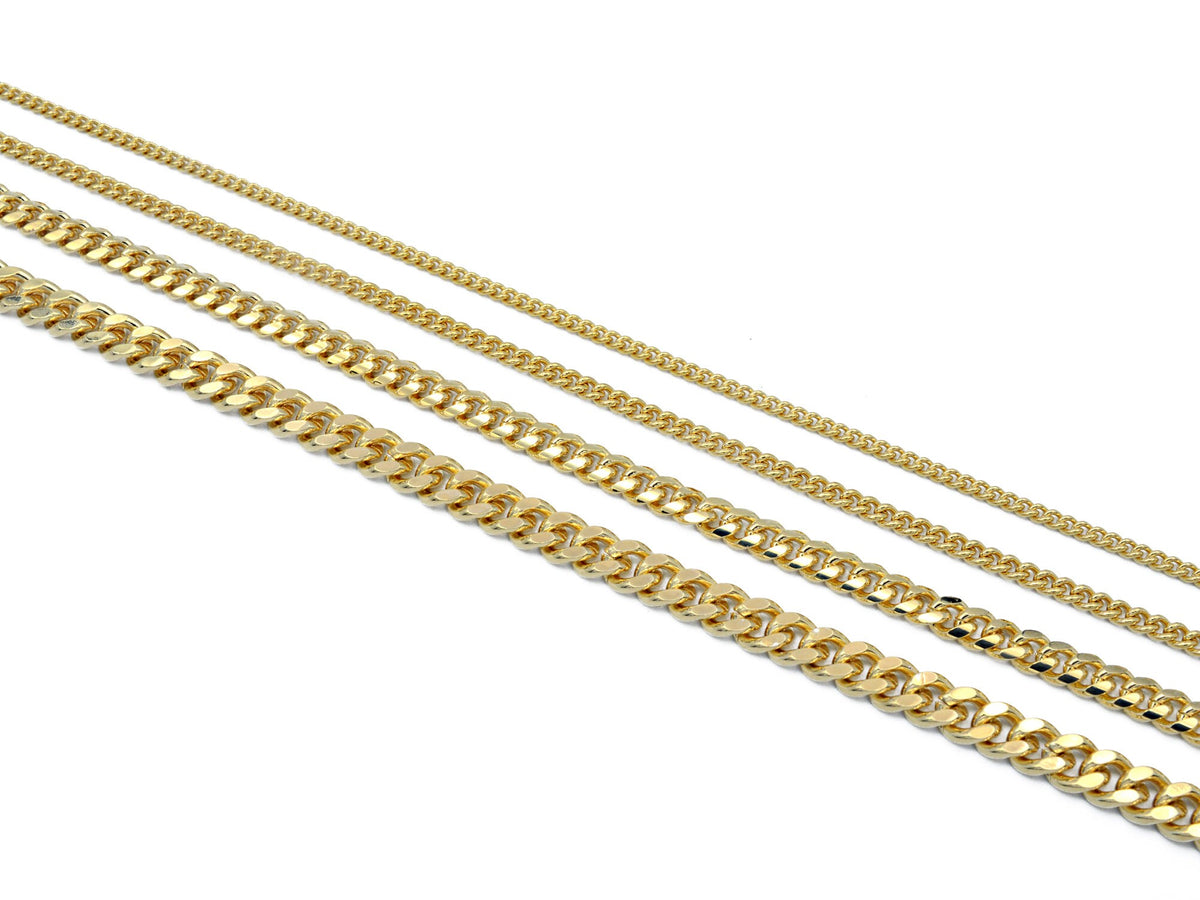 Macro shot of gold tone curb chains on a clean white background, showing the intricate links, smooth texture, and high-gloss tarnish-resistant finish.