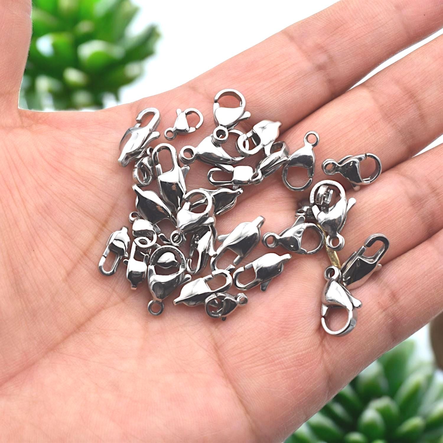 Lobster clasp with mirror finish shown in hand for scale and texture detail.