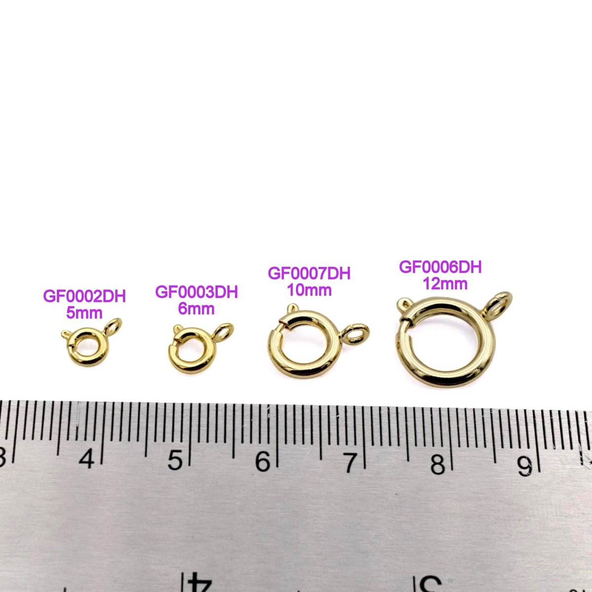 Open gold-filled spring clasp with visible hinge and jump ring, placed beside jewelry-making tools.