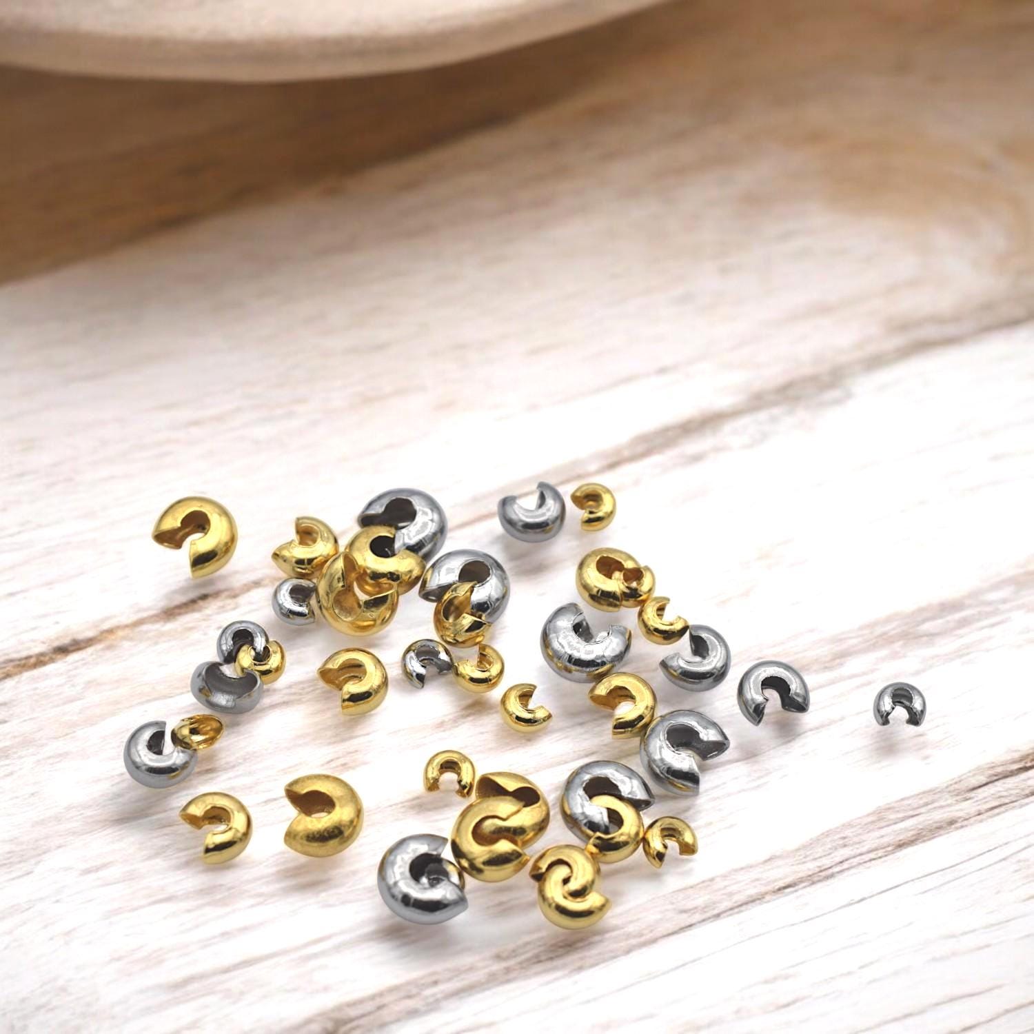 Gold crimp covers placed beside stretch cord and beading wire, ideal for professional bracelet and necklace endings