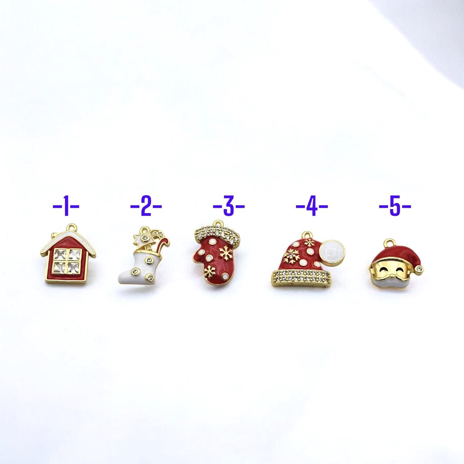 Set of small enamel charms featuring Christmas stocking, Santa hat, mitten, and sparkling holiday house.