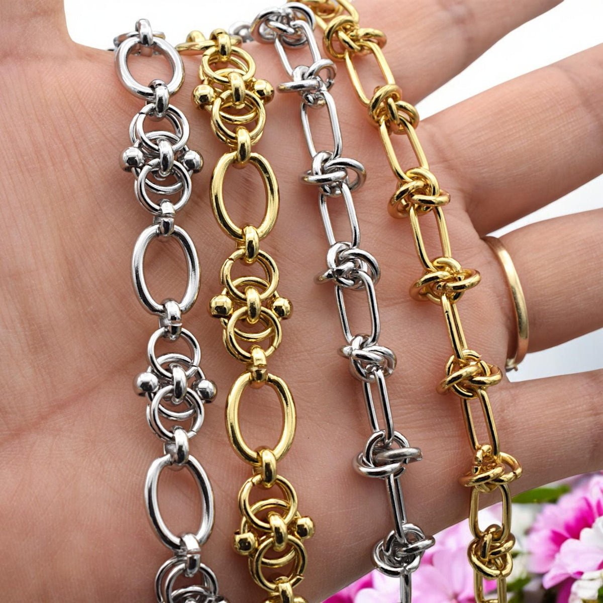 Gold knot chain styled with dried florals and soft lighting, creating a warm lifestyle jewelry scene.