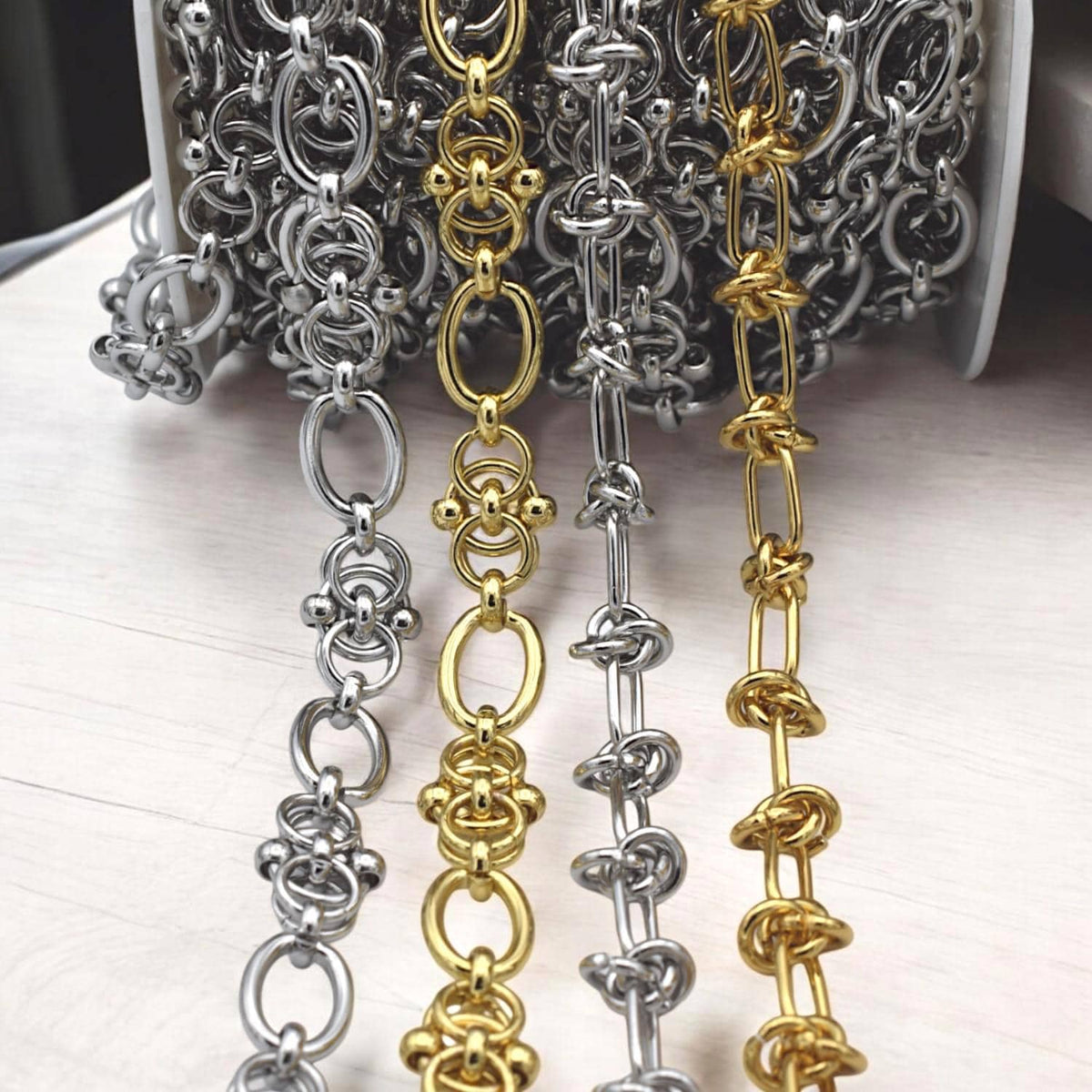 Gold and silver chains arranged diagonally with visible clasp ends, ready for custom necklace assembly.