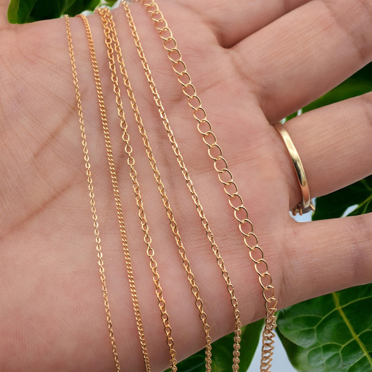 Assorted gold filled extension chains with product codes and measurements visible
