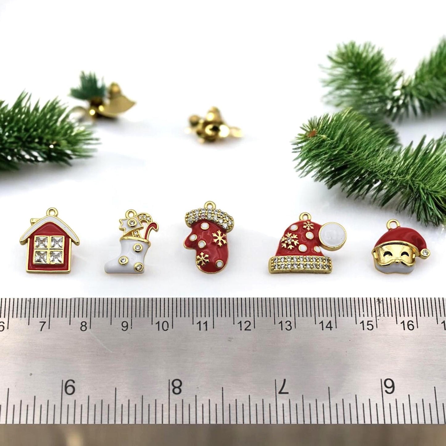 Festive red and white jewelry charms shaped like stocking, mitten, Santa hats, and holiday house with rhinestones.