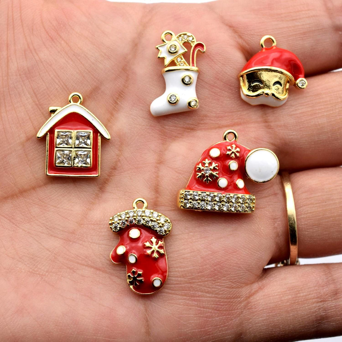 Set of five holiday charms in red, white, and gold with festive motifs and sparkling rhinestone accents.