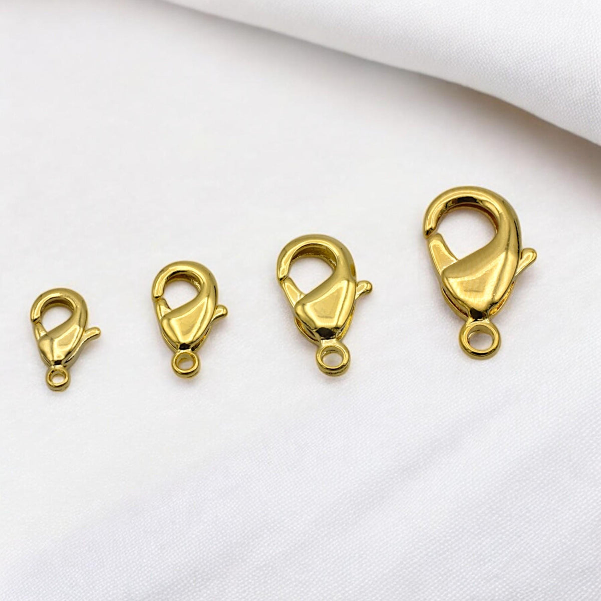 Detailed view of polished gold lobster clasp showing smooth finish and sturdy design