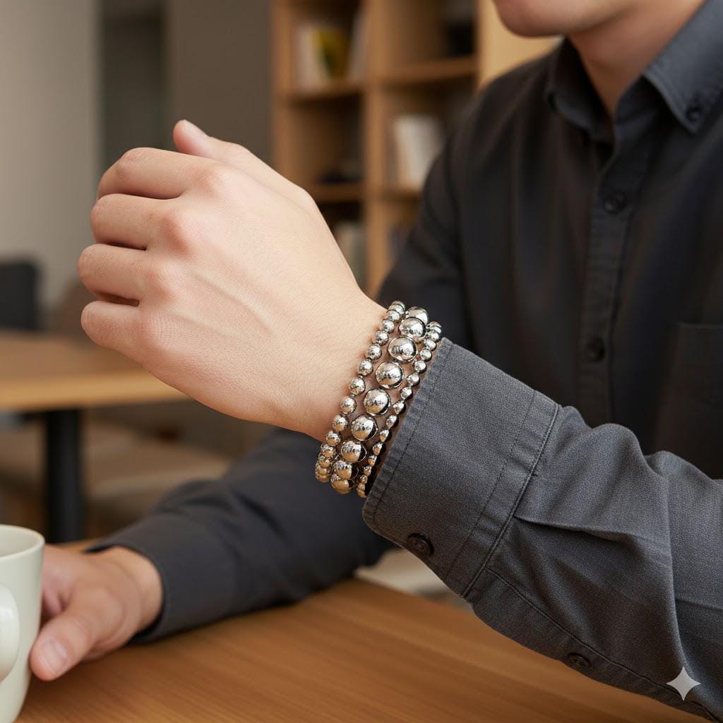 Man stringing stainless steel beads onto a bracelet cord, showing bead size and easy handling