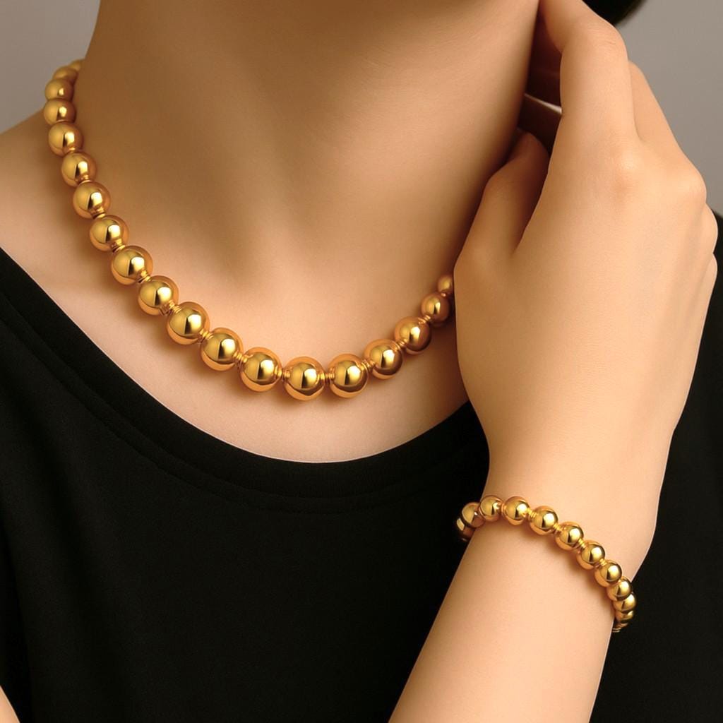 Hand holding small gold-plated spacer beads to show scale and drilled hole size