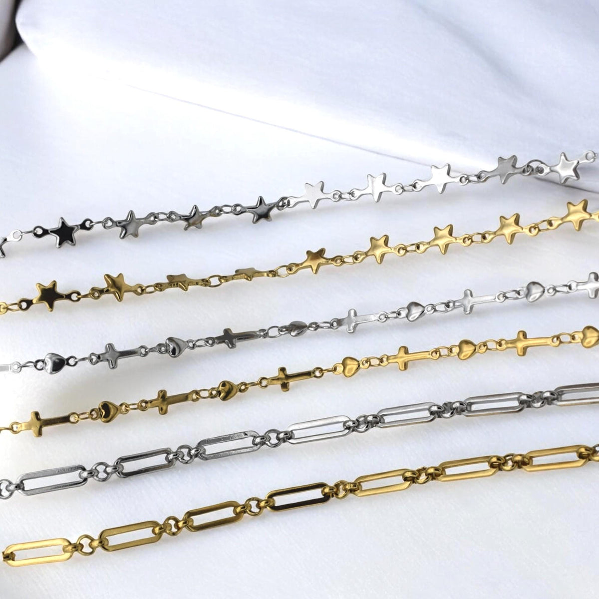 Heart and cross charm chain in silver tone displayed with beads and clasps.