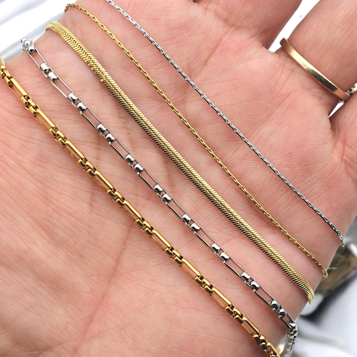 Detailed view of paperclip chain links in stainless steel gold tone, highlighting polished finish.