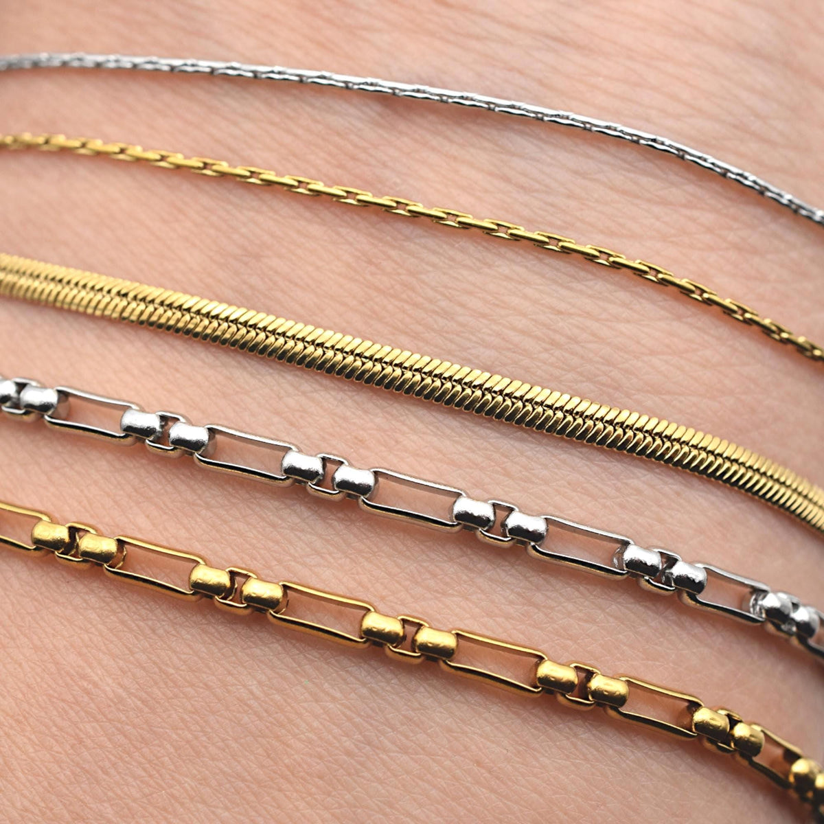 Box chain in gold tone laid flat with clasp findings, ready for DIY necklace projects.