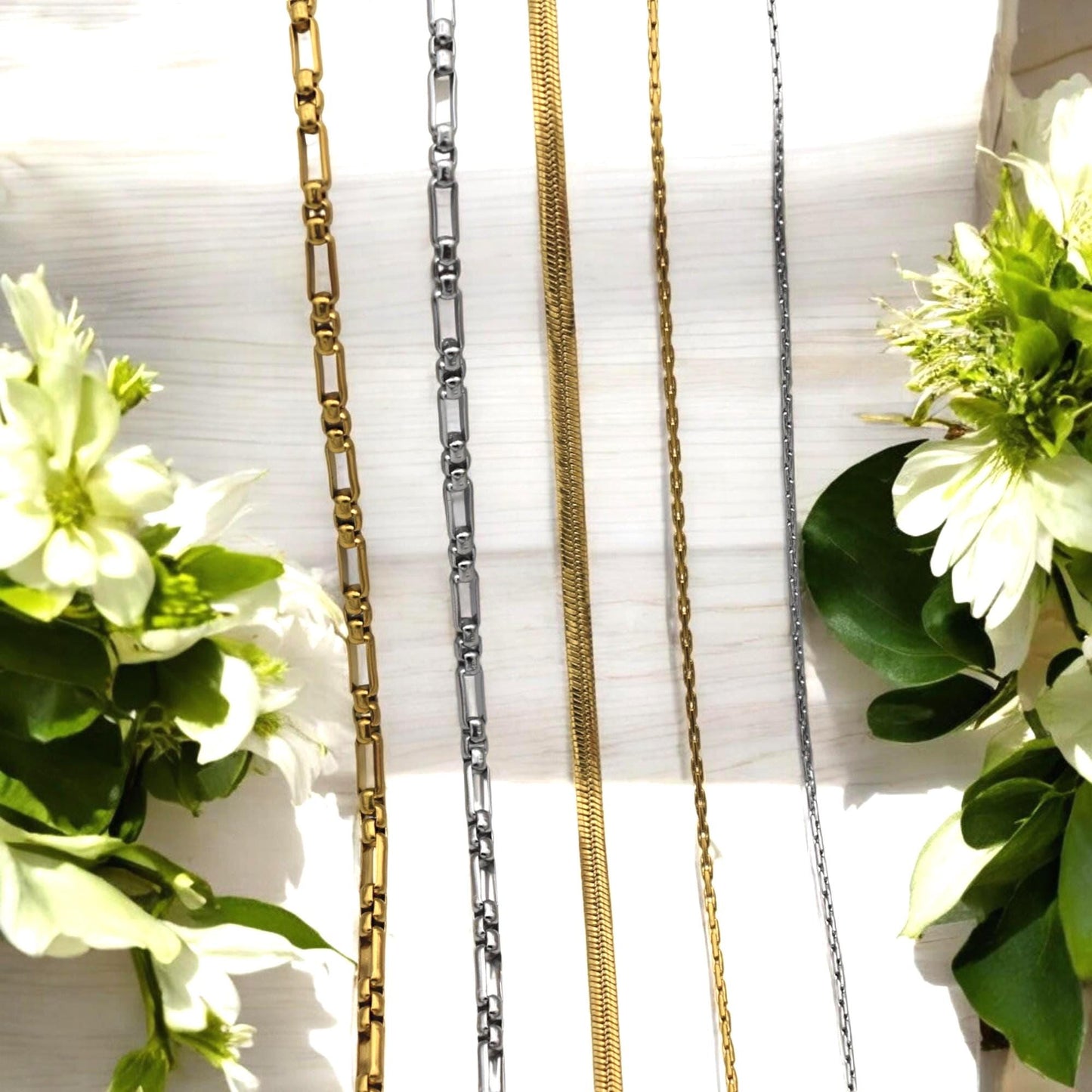 Mixed gold and silver stainless steel chains arranged side by side for comparison.
