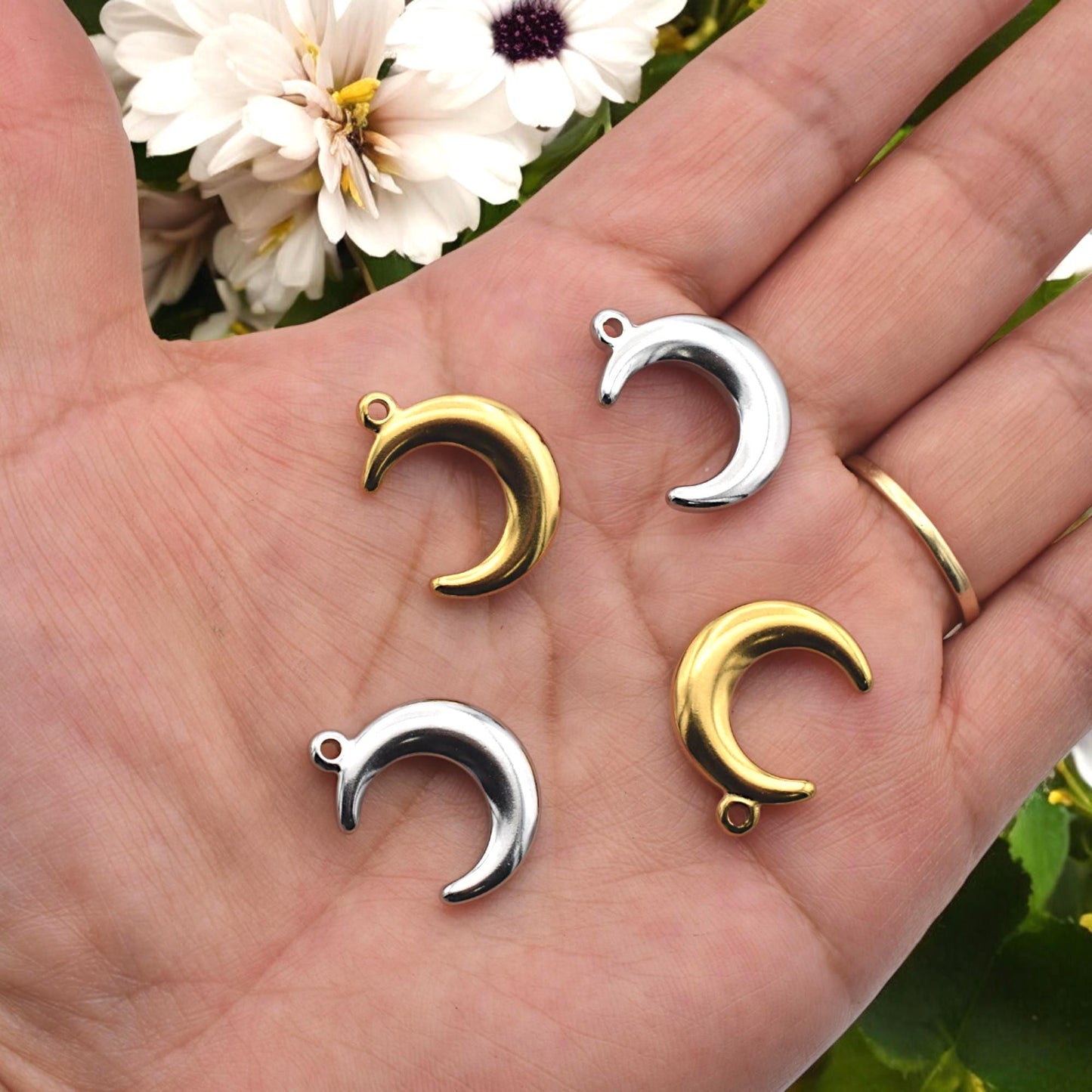 Crescent moon charms displayed in gold‑tone and silver‑tone finishes.
Charms de luna creciente en acabados dorado y plateado.