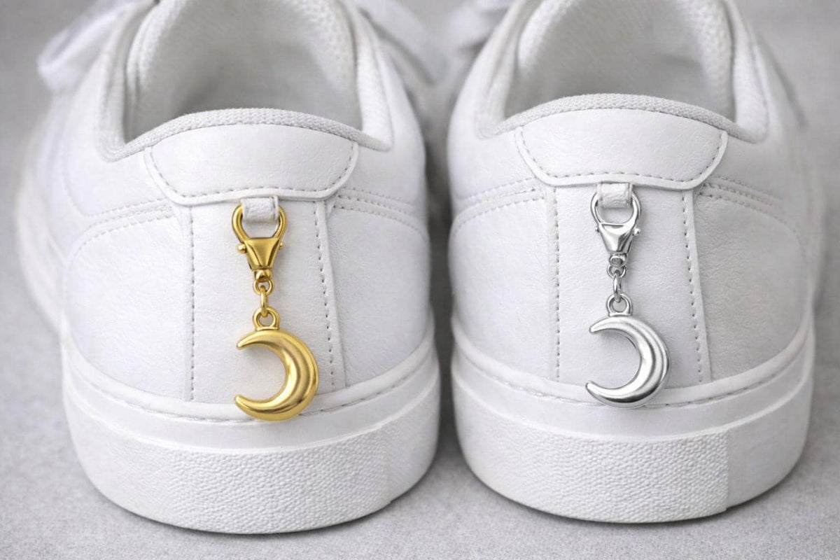 Crescent moon charm shown next to ruler for size reference.
Colgante de luna creciente junto a una regla para referencia de tamaño.