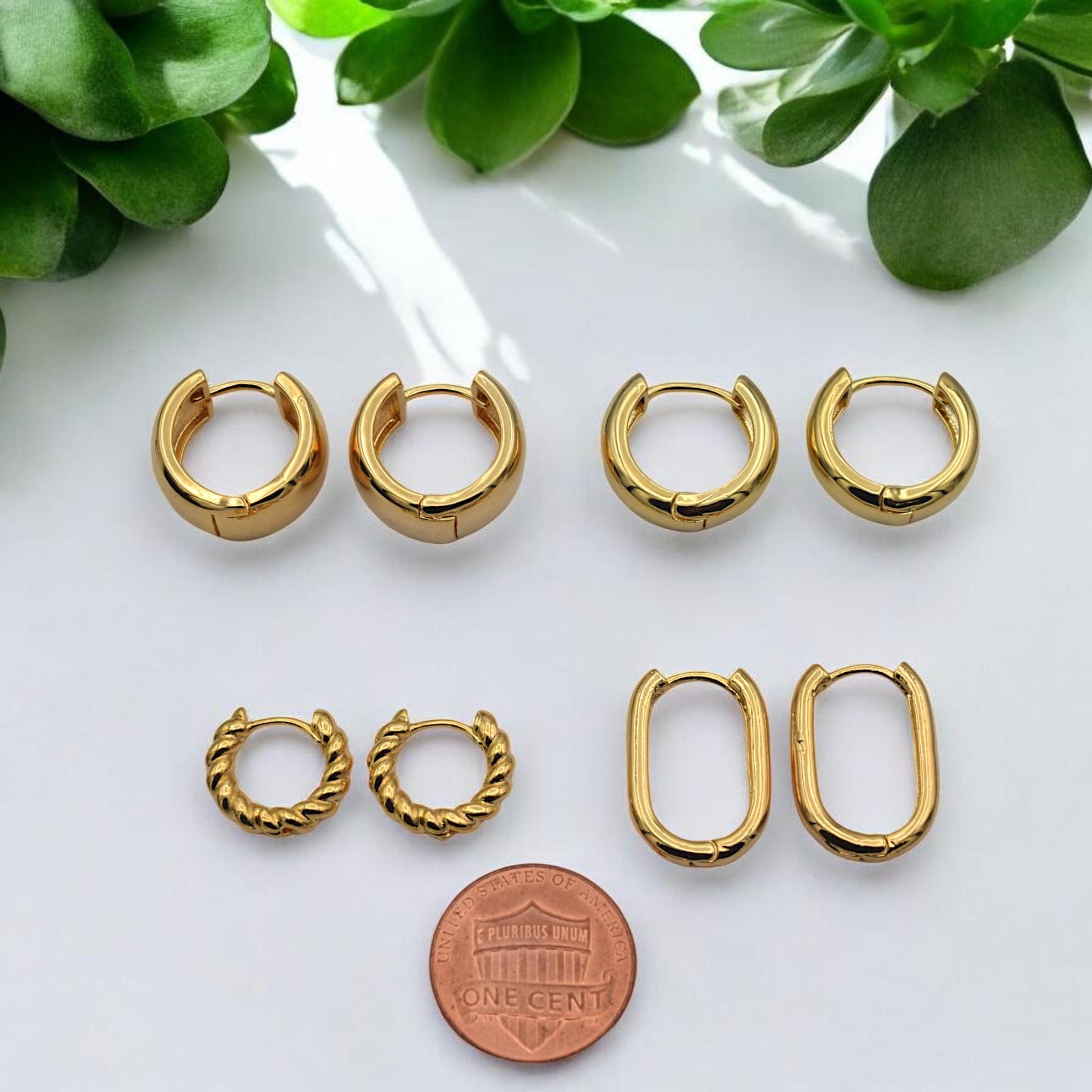 Multiple pairs of gold-filled hoops displayed together, highlighting the contrast between the chunky round styles and the slender oval designs.