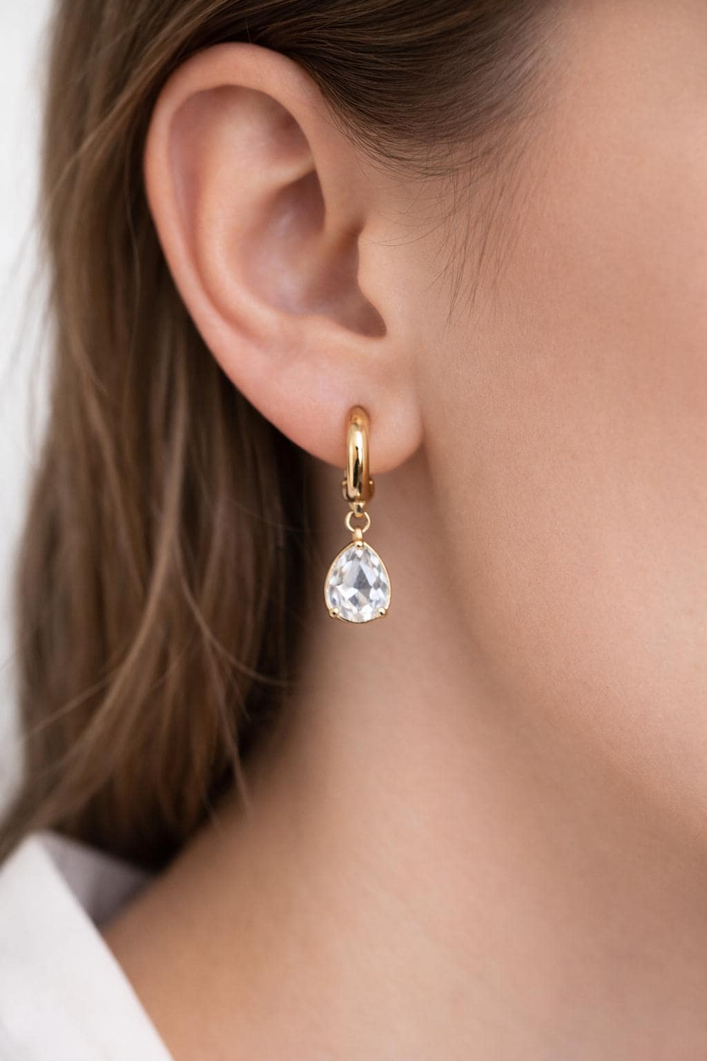 A finished earring example featuring the gold hoop finding paired with a colorful gemstone charm.