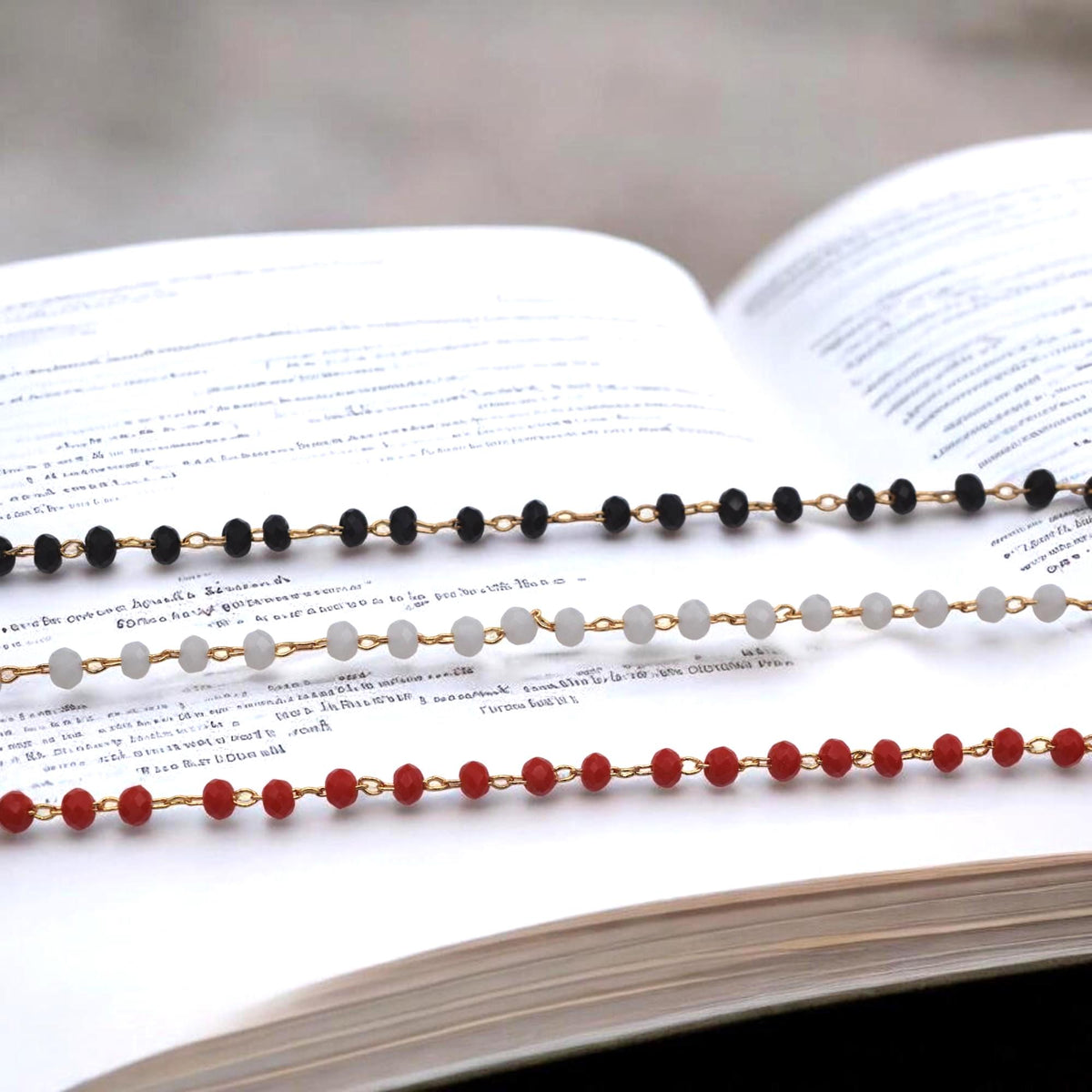 Cadenas de cristal negro, blanco y rojo mostradas juntas para comparar colores.
Mixed black, white, and red crystal rosary chains shown side by side for color comparison.