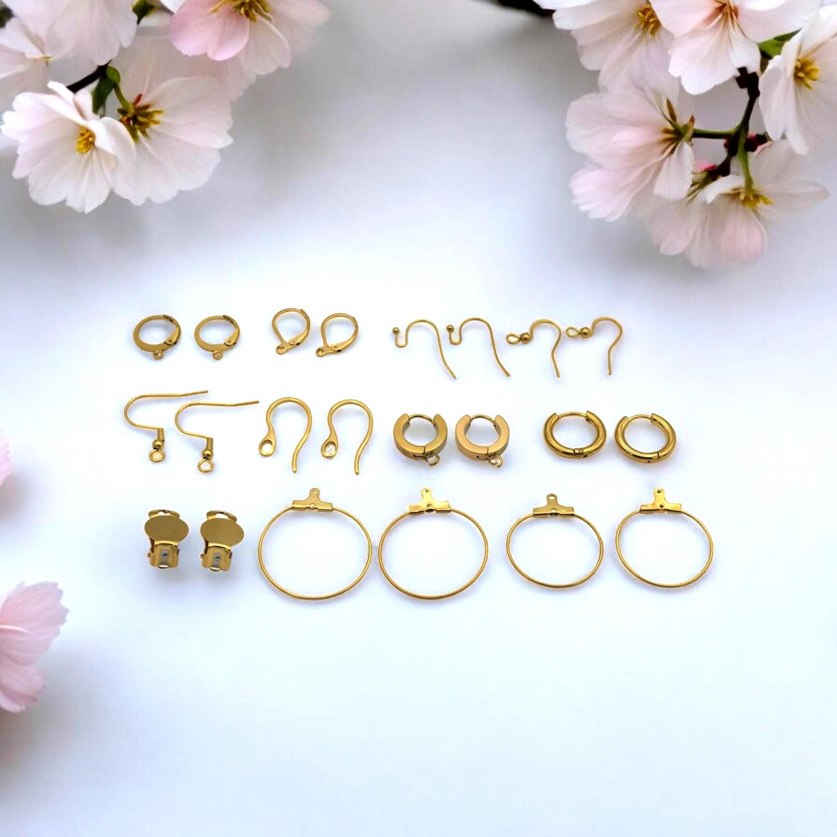 Kidney wire earring hooks in gold stainless steel laid out in a row.
Ganchos tipo kidney en acero inoxidable dorado alineados en fila.