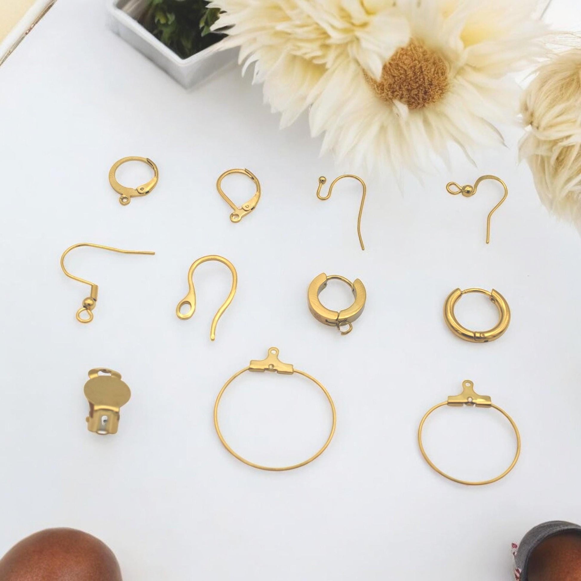 Bases tipo clip-on en acero inoxidable dorado junto a cuentas facetadas.
Clip-on earring bases in gold stainless steel shown with faceted beads.
