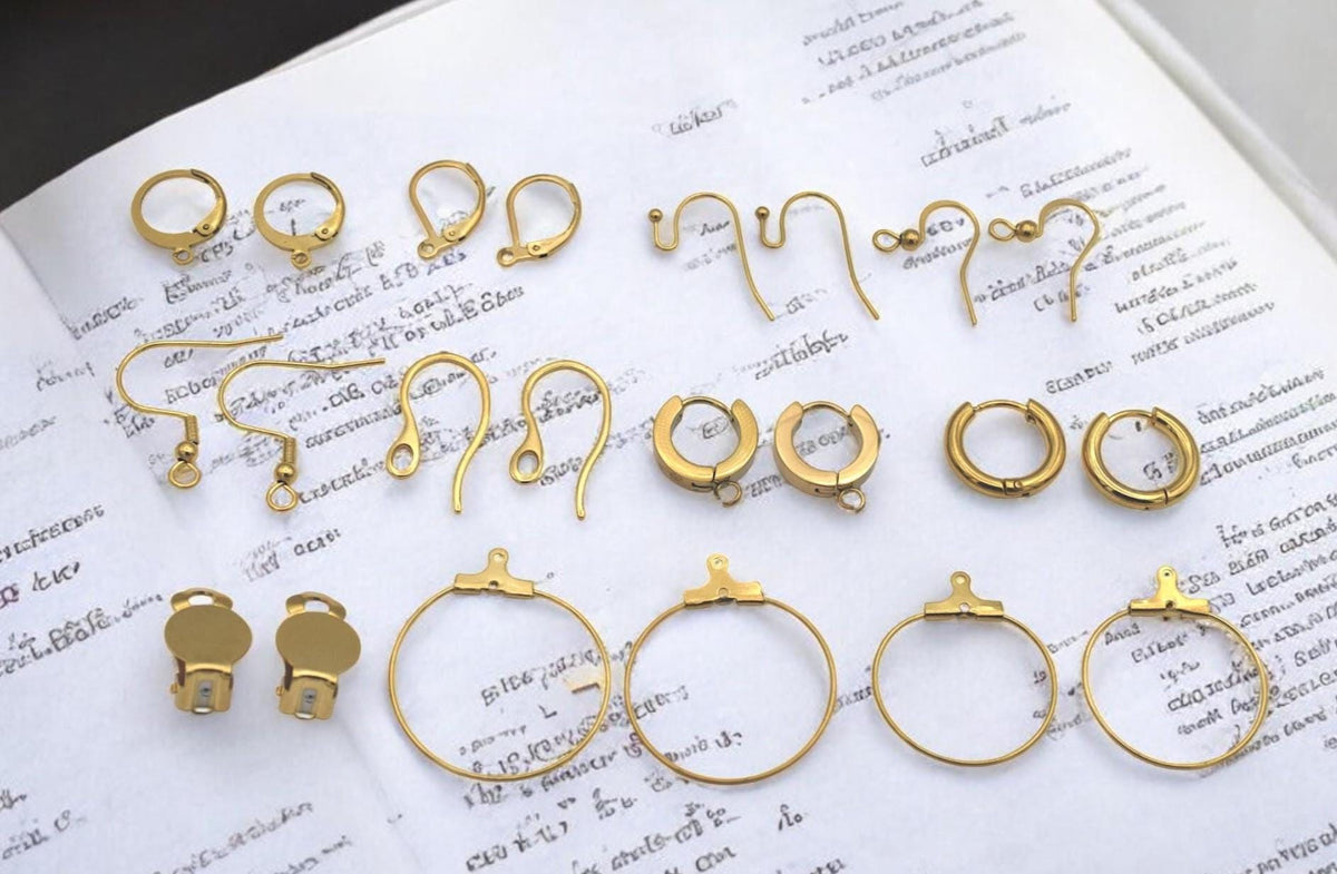 Small gold hoops with hinged closure displayed with jewelry-making tools.
Aros pequeños dorados con cierre de bisagra mostrados con herramientas de joyería.