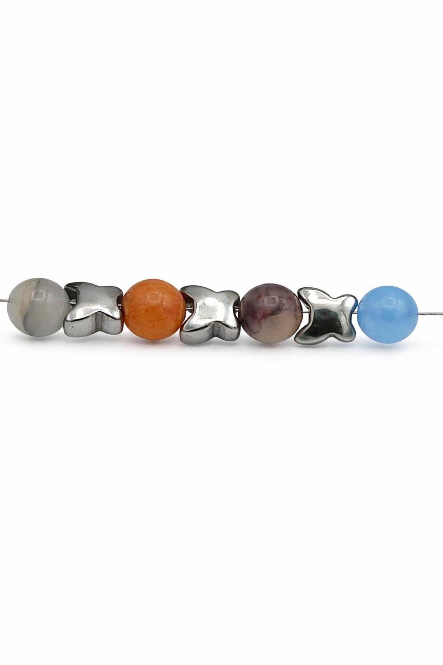 a row of colorful beads, including a gray ball, an orange ball, a purple ball, a silver ball, and a blue ball, arranged in a row.