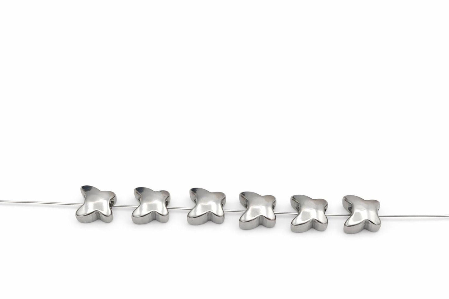A row of silver beads on a white background.