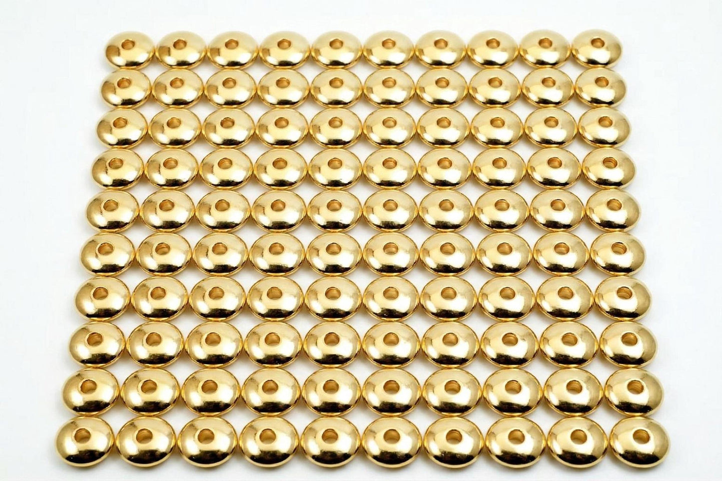 a grid of numerous gold-colored metal balls arranged in a repeating pattern.