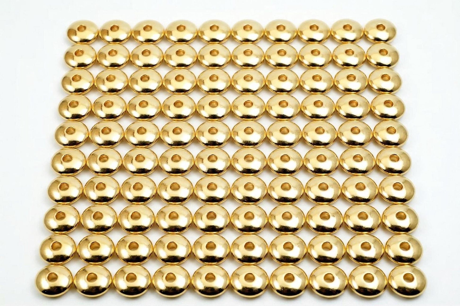 a grid of numerous gold-colored metal balls arranged in a repeating pattern.