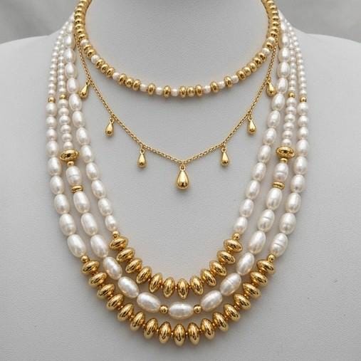 A gold and white pearl necklace with multiple strands of pearls and beads.