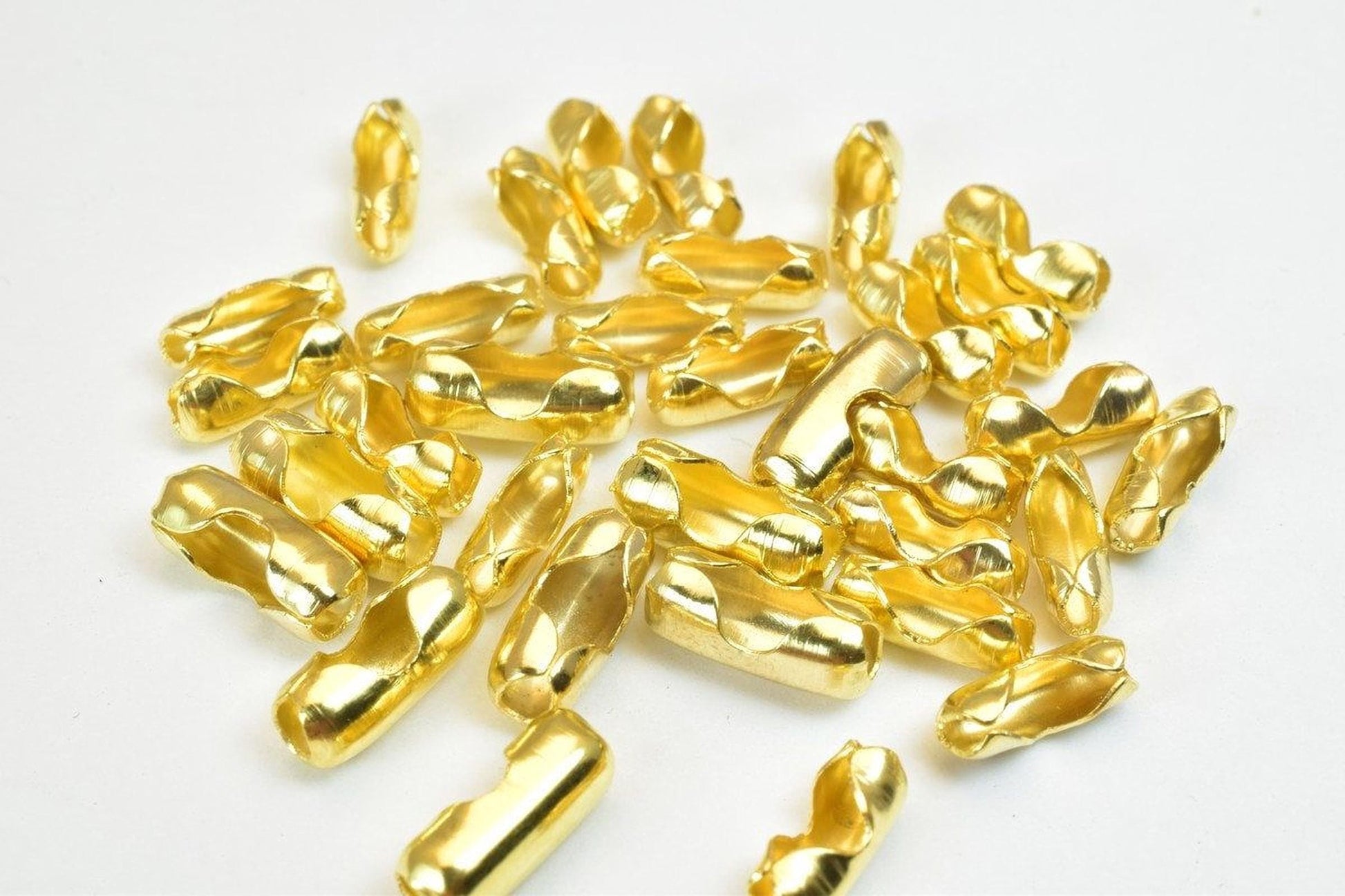 a collection of golden-colored metal pieces scattered on a white background.
